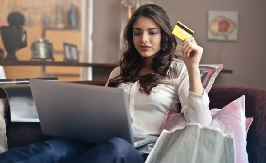 Une femme devant son ordinateur avec carte bancaire