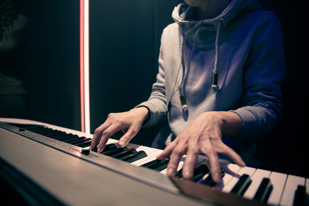 jeune homme qui joue du piano numérique